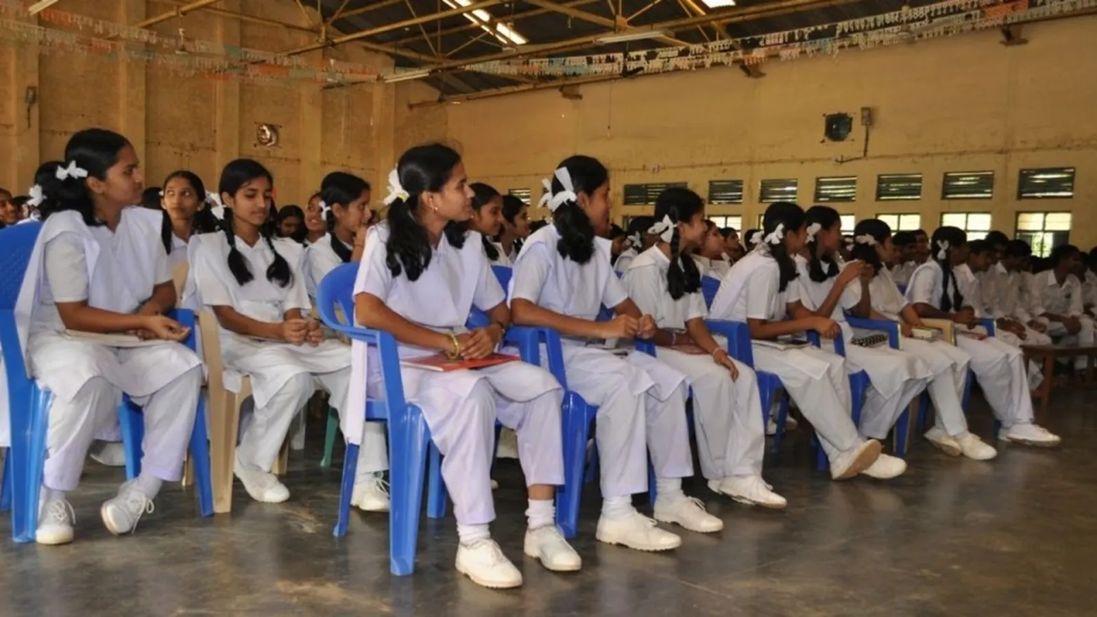 Students seated in rows in the school hall.